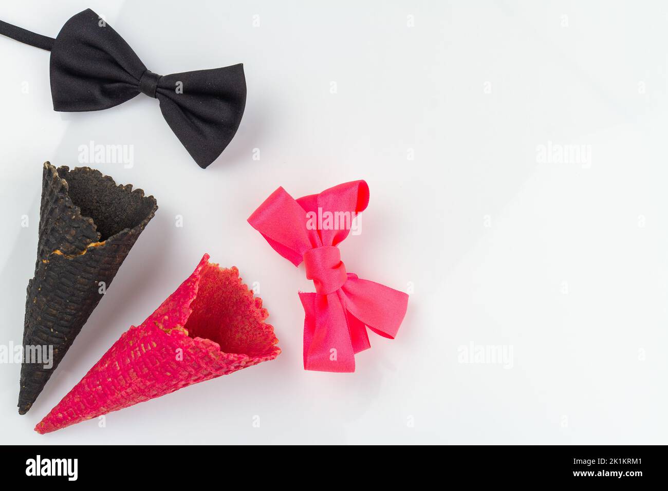 Top view male and female ice cream cones with copy space. Black and pink bow ties. Stock Photo