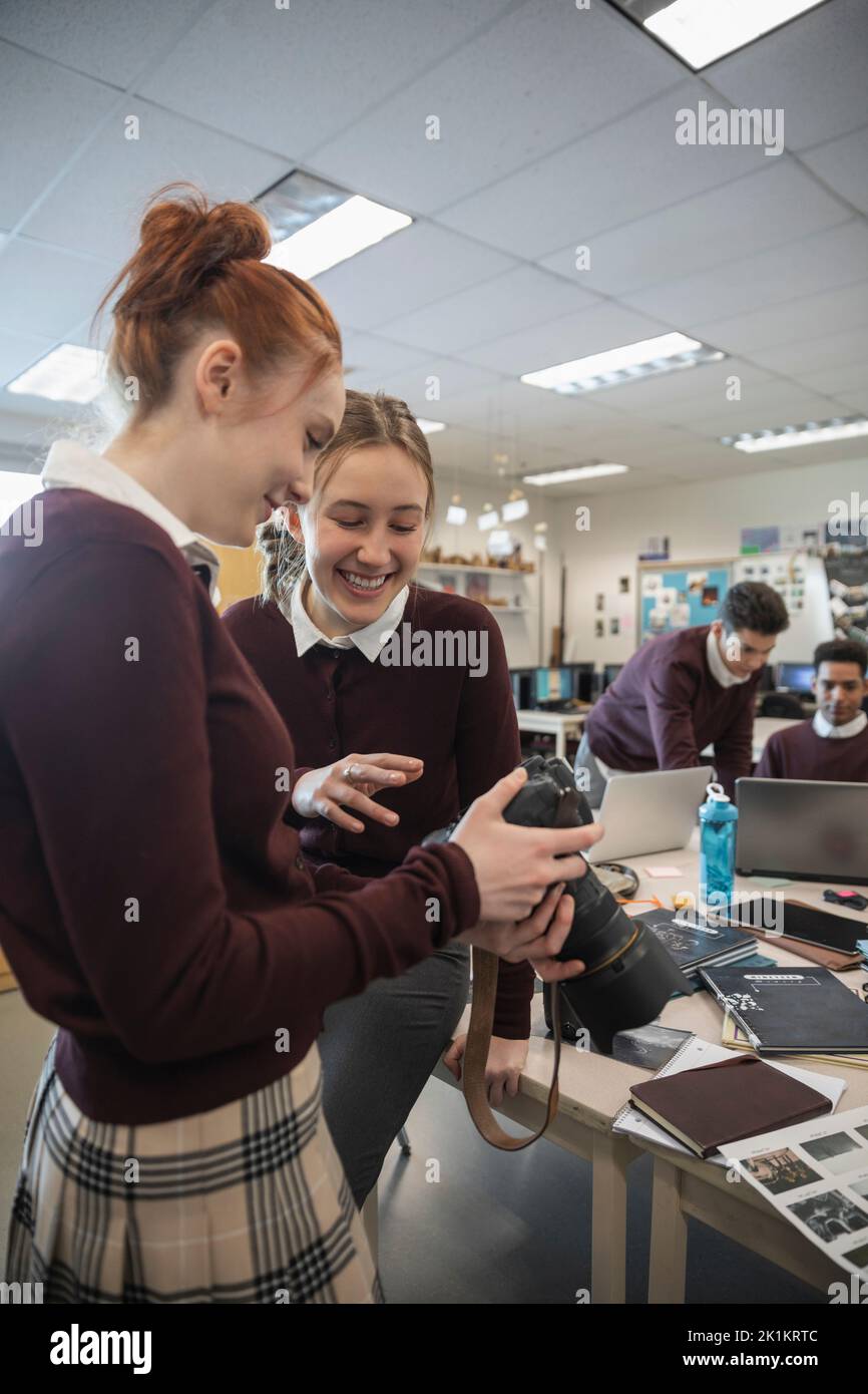 High school girls with digital camera working on yearbook Stock Photo