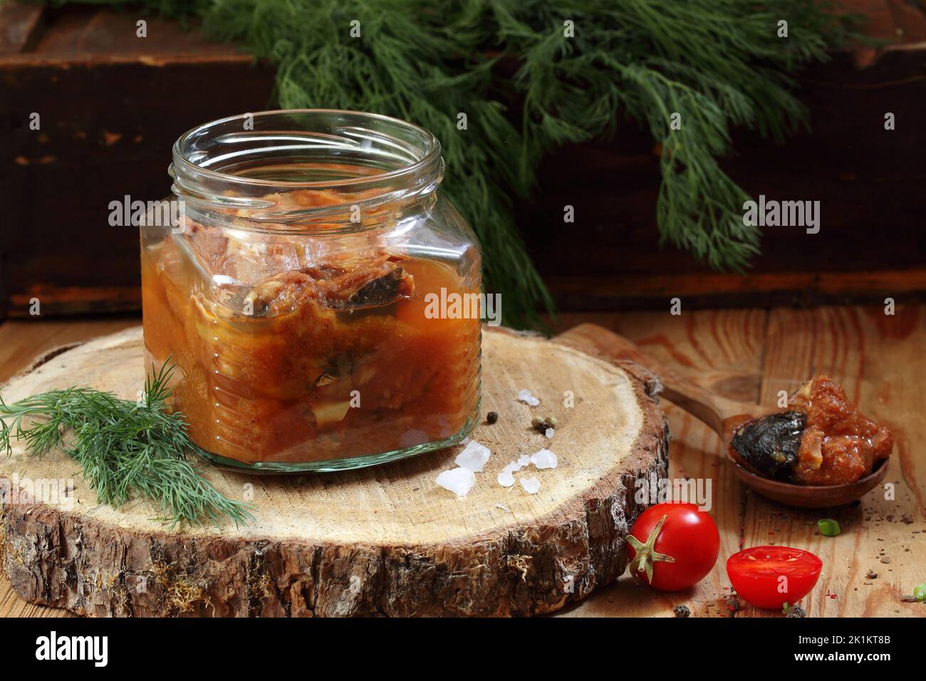 Catfish canned in tomato on a wooden table in a glass jar Stock Photo