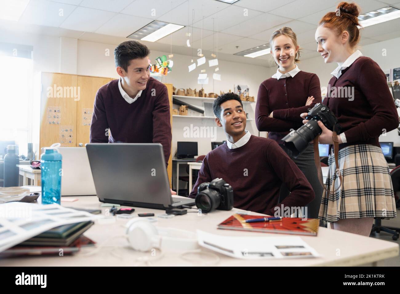 High school students with digital cameras working on yearbook Stock