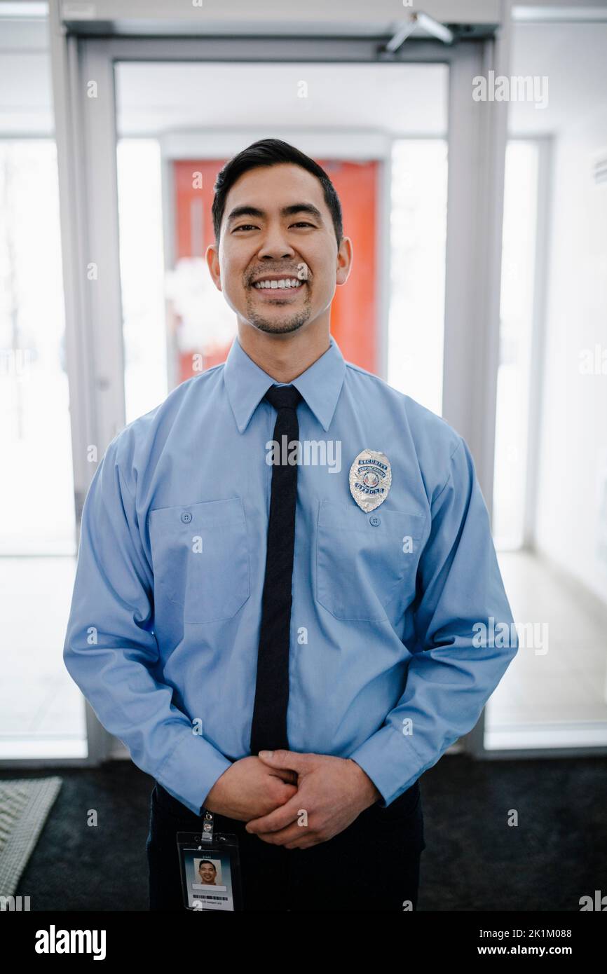 Portrait of security guard wearing badge and smiling Stock Photo Alamy