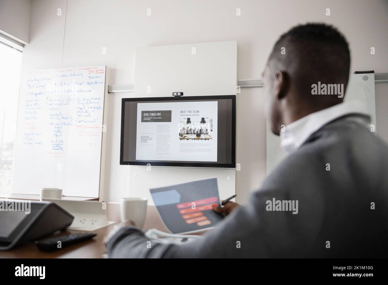 Man looking at screen in meeting room Stock Photo