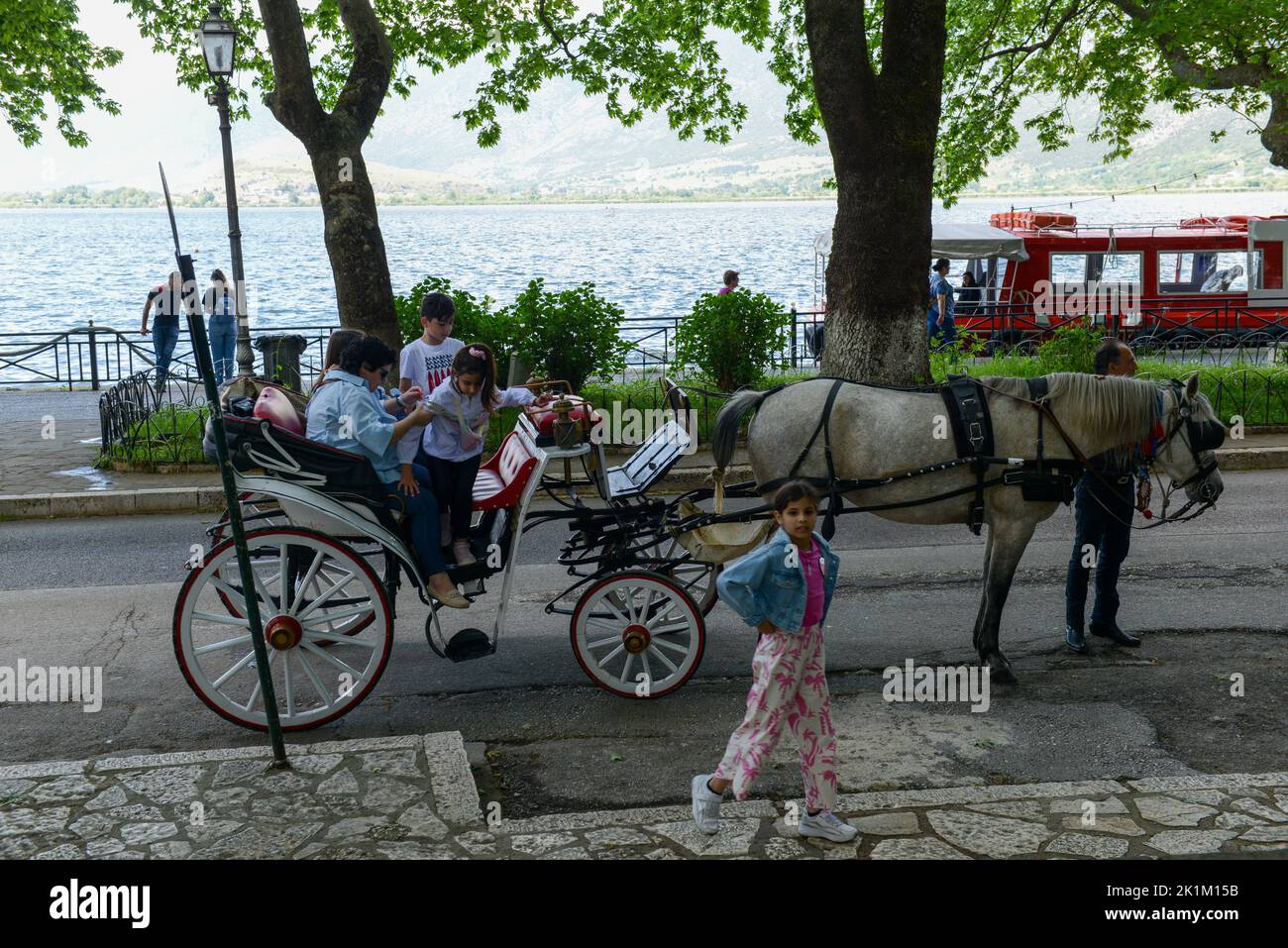 Ioannina, Greece - 16 May 2022: people traveling in a horse-drawn carriage at Ioannina on Greece Stock Photo