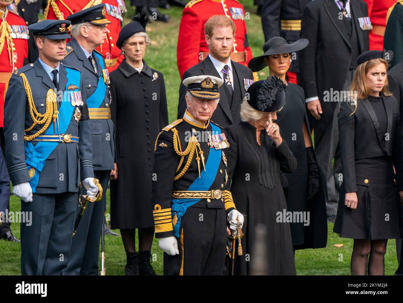 The Prince of Wales, King Charles III, the Duke of Sussex, the Queen Consort, the Duchess of Sussex and Princess Beatrice look on as the State Gun Carriage carrying the coffin of Queen Elizabeth II arrives at Wellington Arch during the Ceremonial Procession following her State Funeral at Westminster Abbey, London. Stock Photo