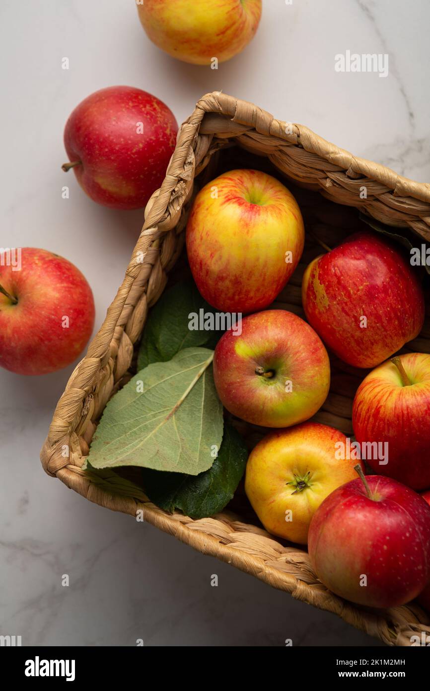 Yellow and red apples in crate on light surface food harvest concept Stock Photo