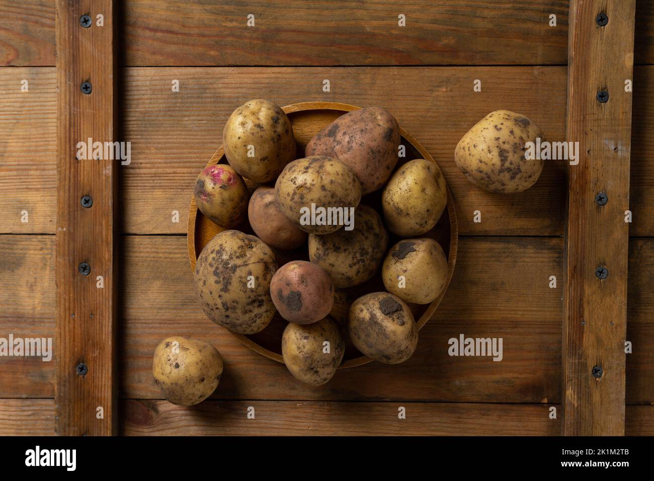 Fresh harvest of potatoes on wooden surface food top view Stock Photo