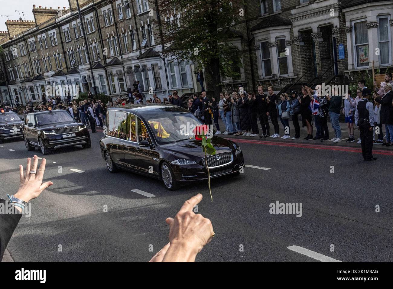 A person throws a flower towards Britain's Queen Elizabeth's coffin, as it is transported, on the day of her state funeral and burial, in London, Britain, September 19, 2022. REUTERS/Carlos Barria Stock Photo