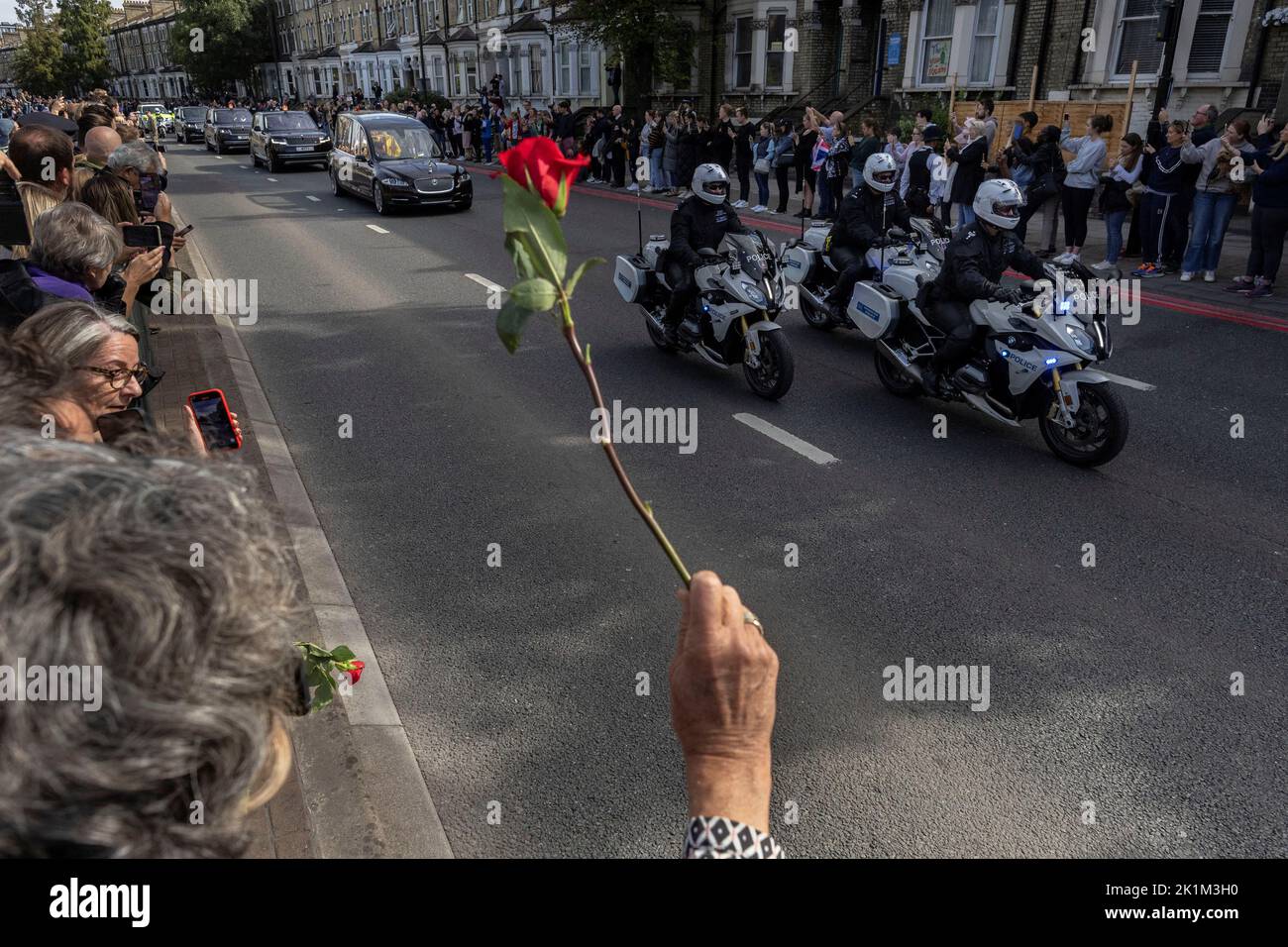 A person holds a flower, as Britain's Queen Elizabeth's coffin is transported, on the day of her state funeral and burial, in London, Britain, September 19, 2022. REUTERS/Carlos Barria Stock Photo