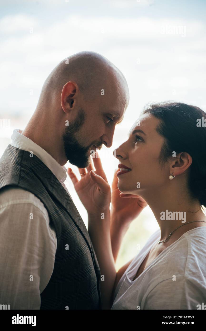 Romantic couple. Family photo. Trustful love. Happy together. Beloved man and woman looking sensually each other isolated on white side view. Stock Photo