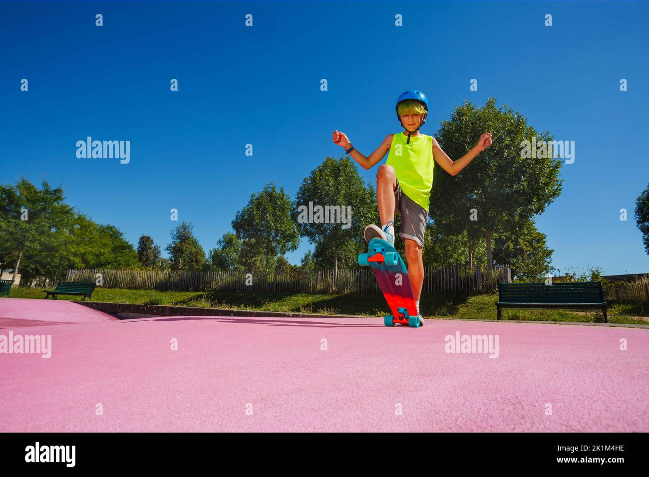 Young boy skate his skateboard at skatepark pose on ramp Stock Photo