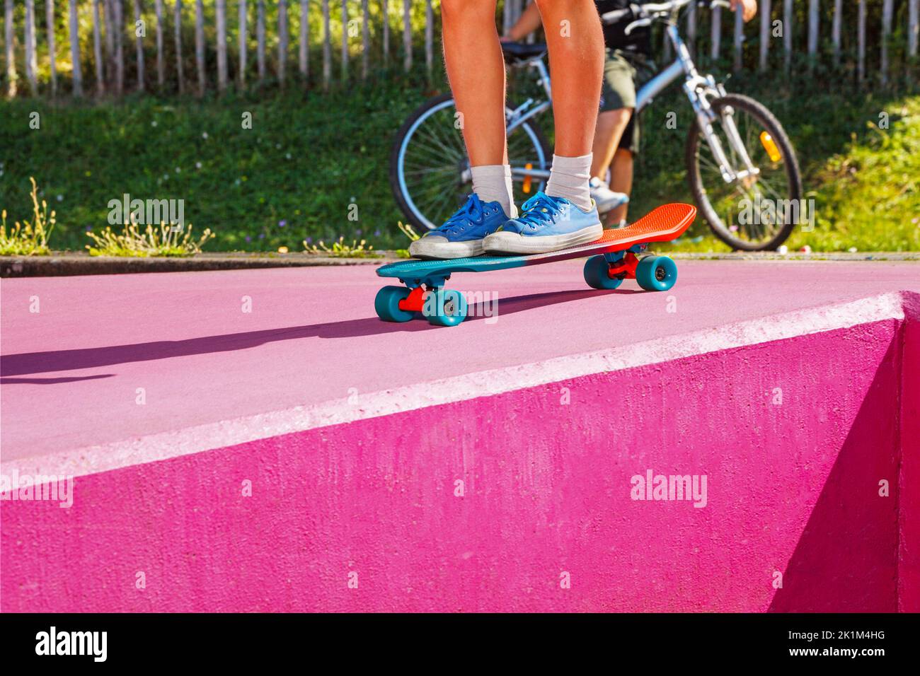 Legs of teenage boy skate riding a skateboard at skatepark Stock Photo