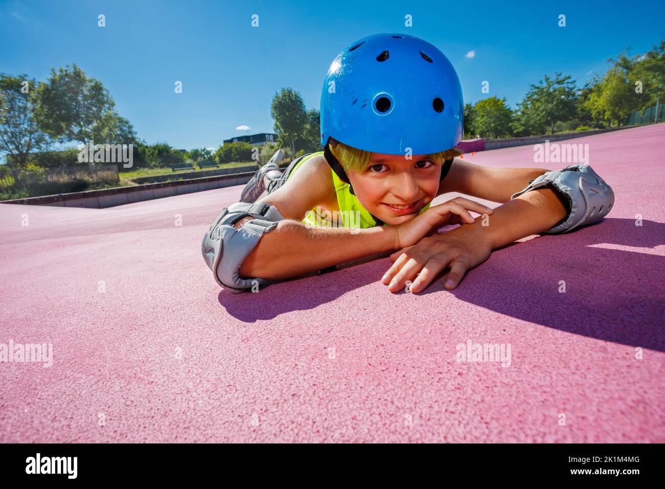 Boy in rollerblades at skatepark rest on color surface smiling Stock Photo