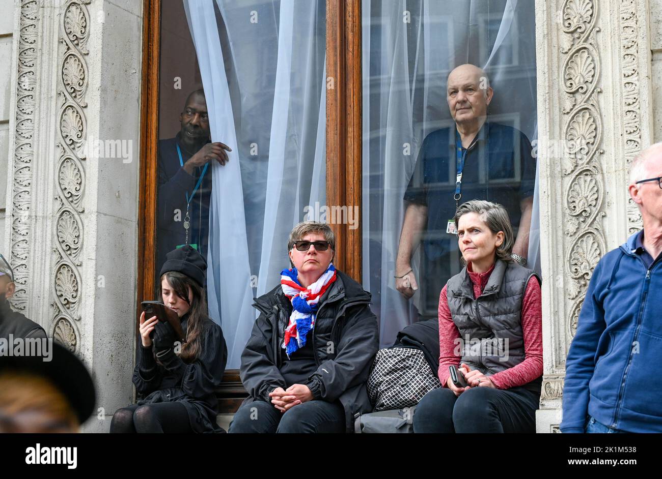 London, UK. 19th Sep, 2022. London UK 19th September 2022 - Workers peek out through windows as crowds in Whitehall watch the funeral procession of Queen Elizabeth II in London today: Credit Simon Dack / Alamy Live News Credit: Simon Dack News/Alamy Live News Stock Photo
