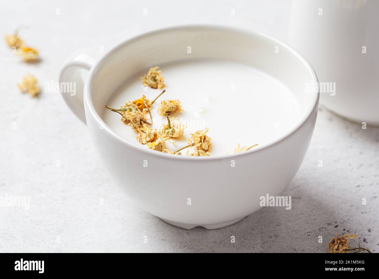 Chamomile moon milk in a white cup. Ayurveda drink, chamomile latte tea. Stock Photo