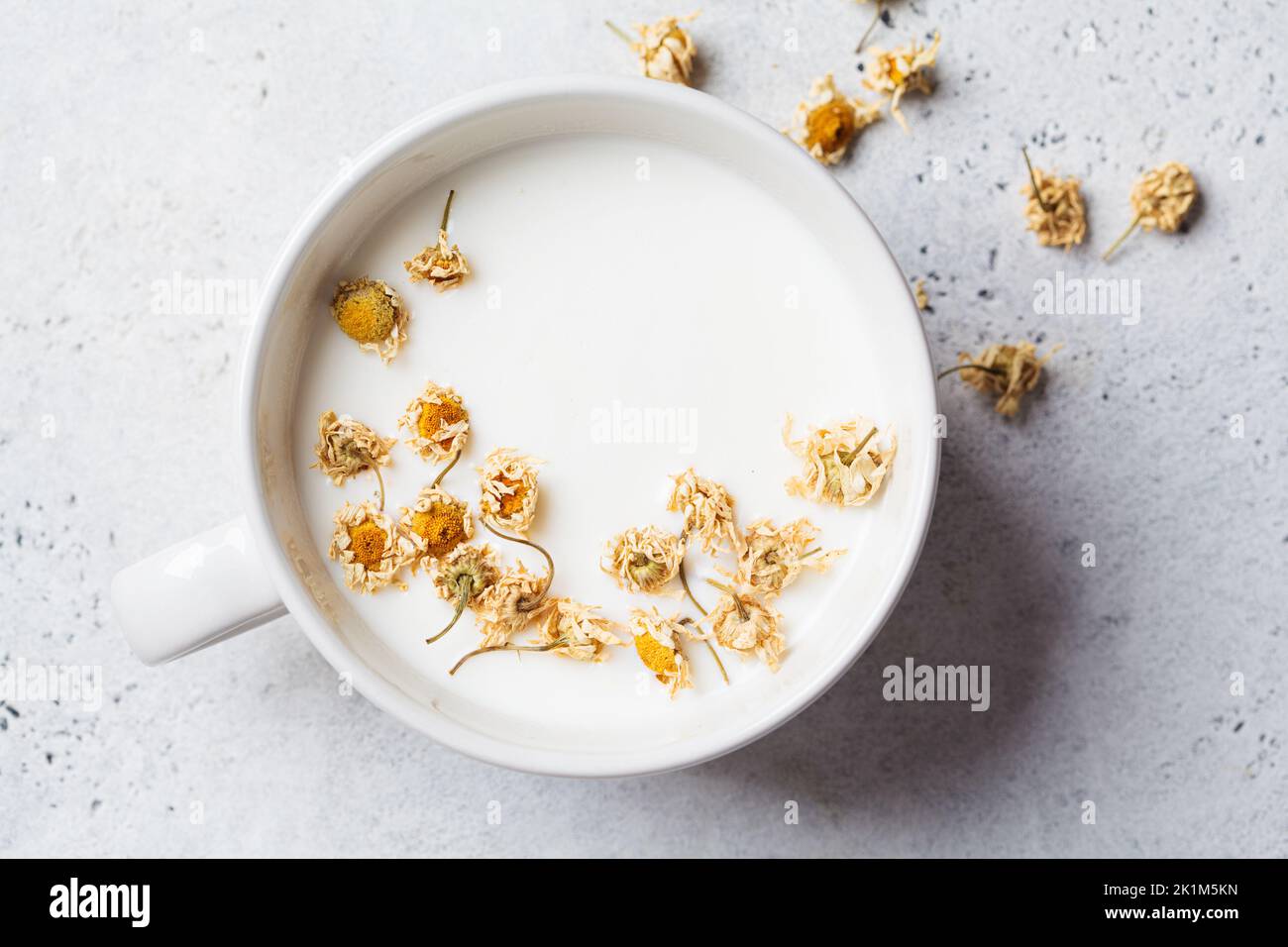 Chamomile moon milk in a white cup, top view. Ayurveda drink, chamomile latte tea Stock Photo