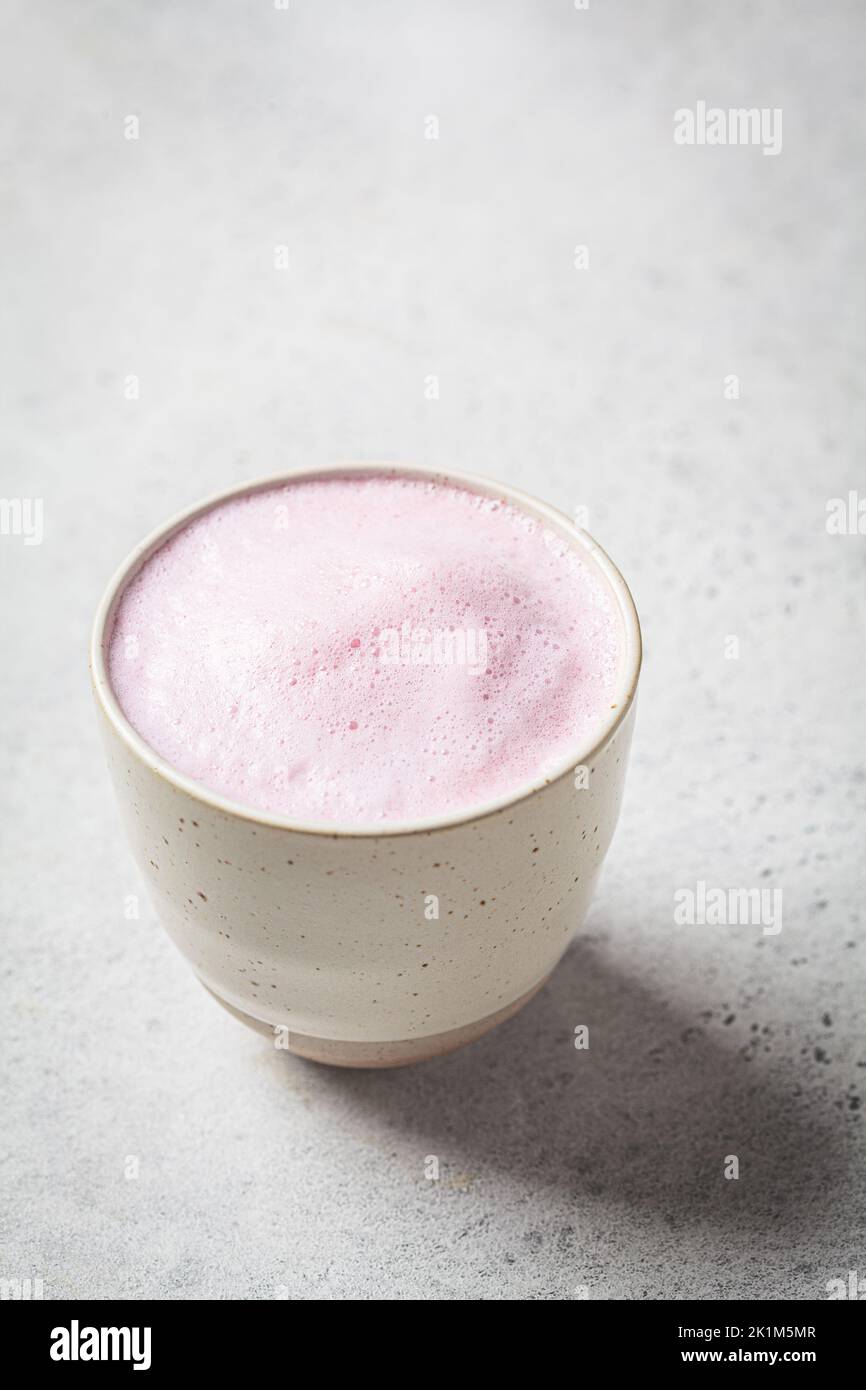 Pink flower moon milk in a white cup. Ayurveda drink, healthy lifestyle, remedy for insomnia. Stock Photo