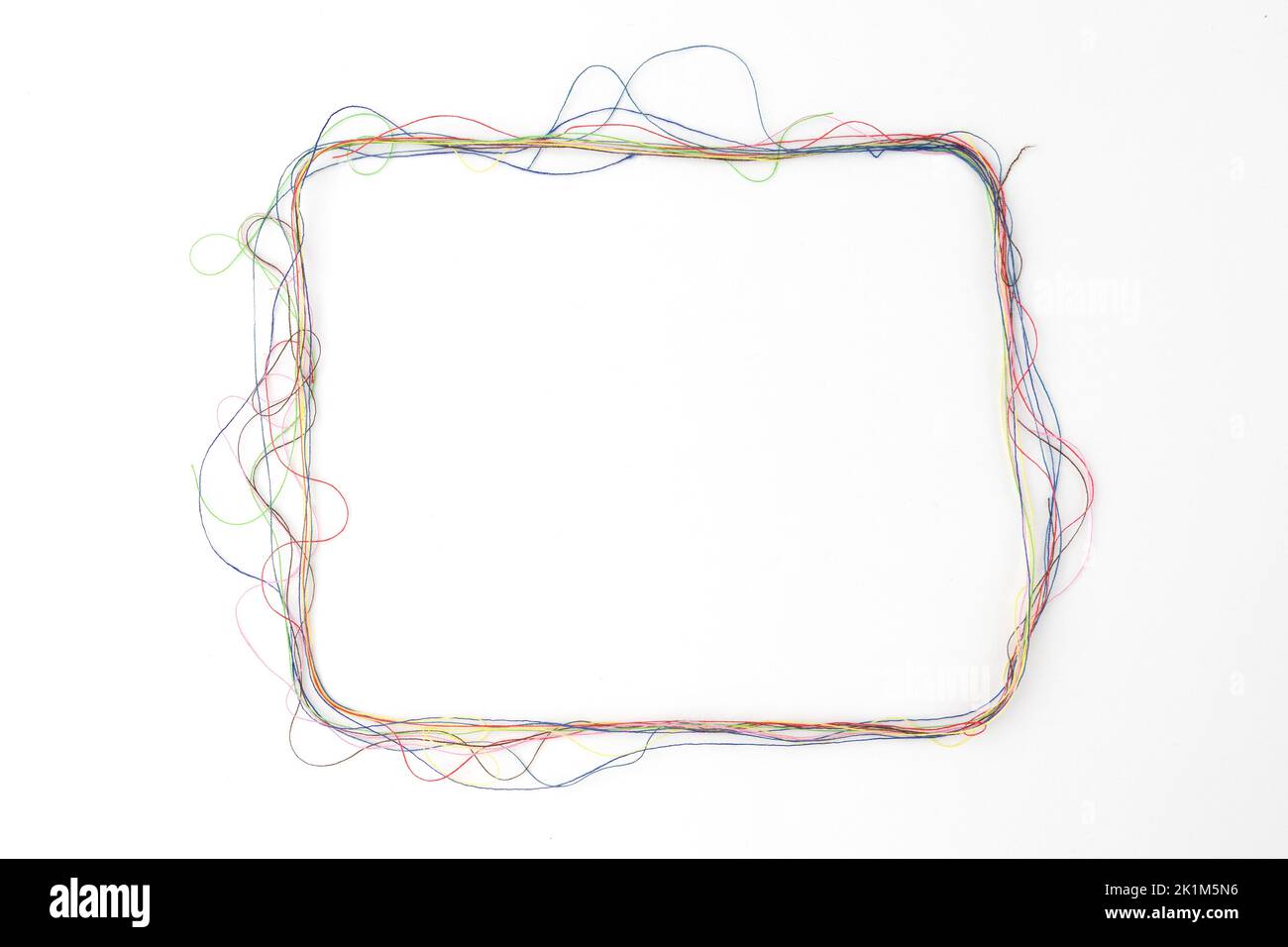 flat lay sewing composition with threads on white background, frame of