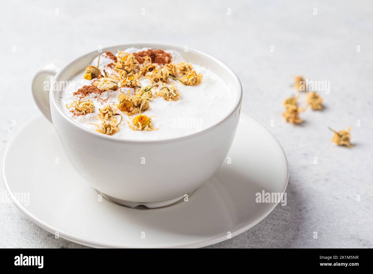 Chamomile moon milk with cinnamon in a white cup. Ayurveda drink, chamomile latte tea. Stock Photo