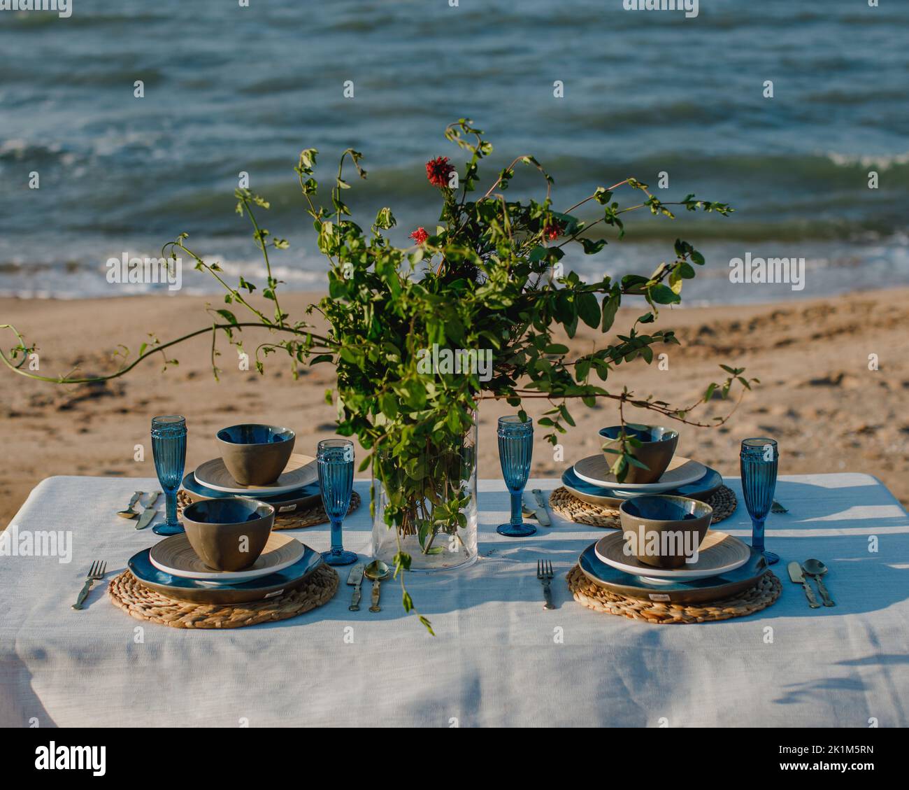 An elegant display set utensils on the table in the seashore Stock
