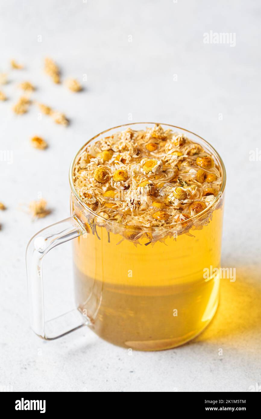 Chamomile tea with flowers in a glass cup. Healthy herbal drink, natural antiseptic and aid in digestion. Stock Photo