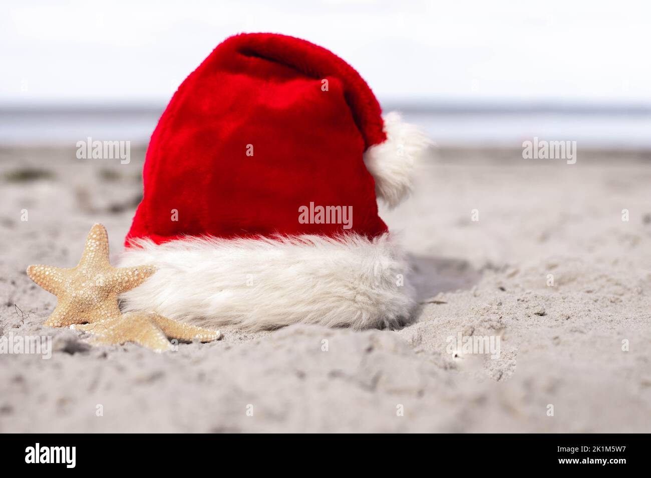 Christmas background Santa Claus hat on the beach with starfish Stock ...