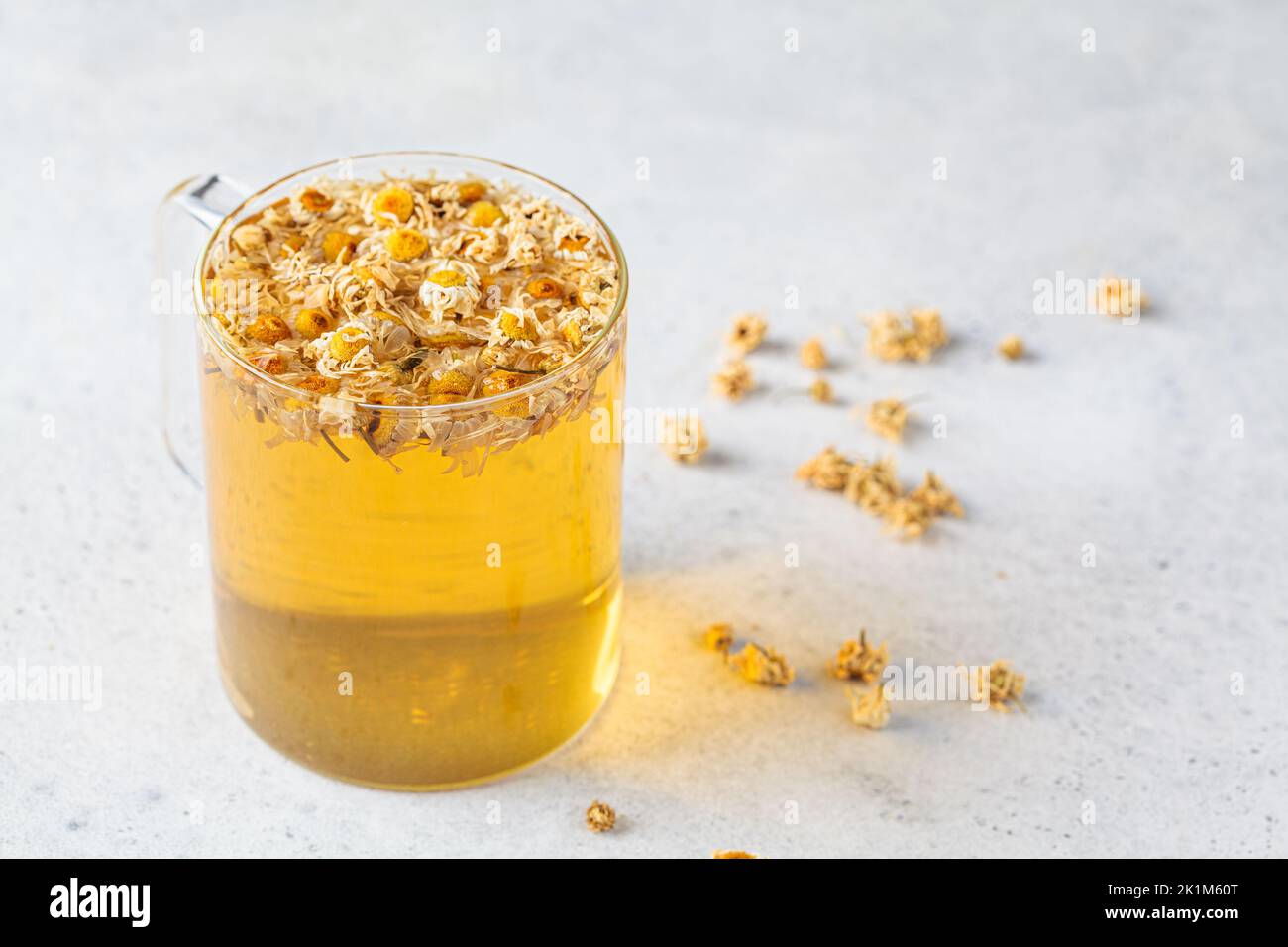 Chamomile tea with flowers in a glass cup. Healthy herbal drink, natural antiseptic and aid in digestion. Stock Photo