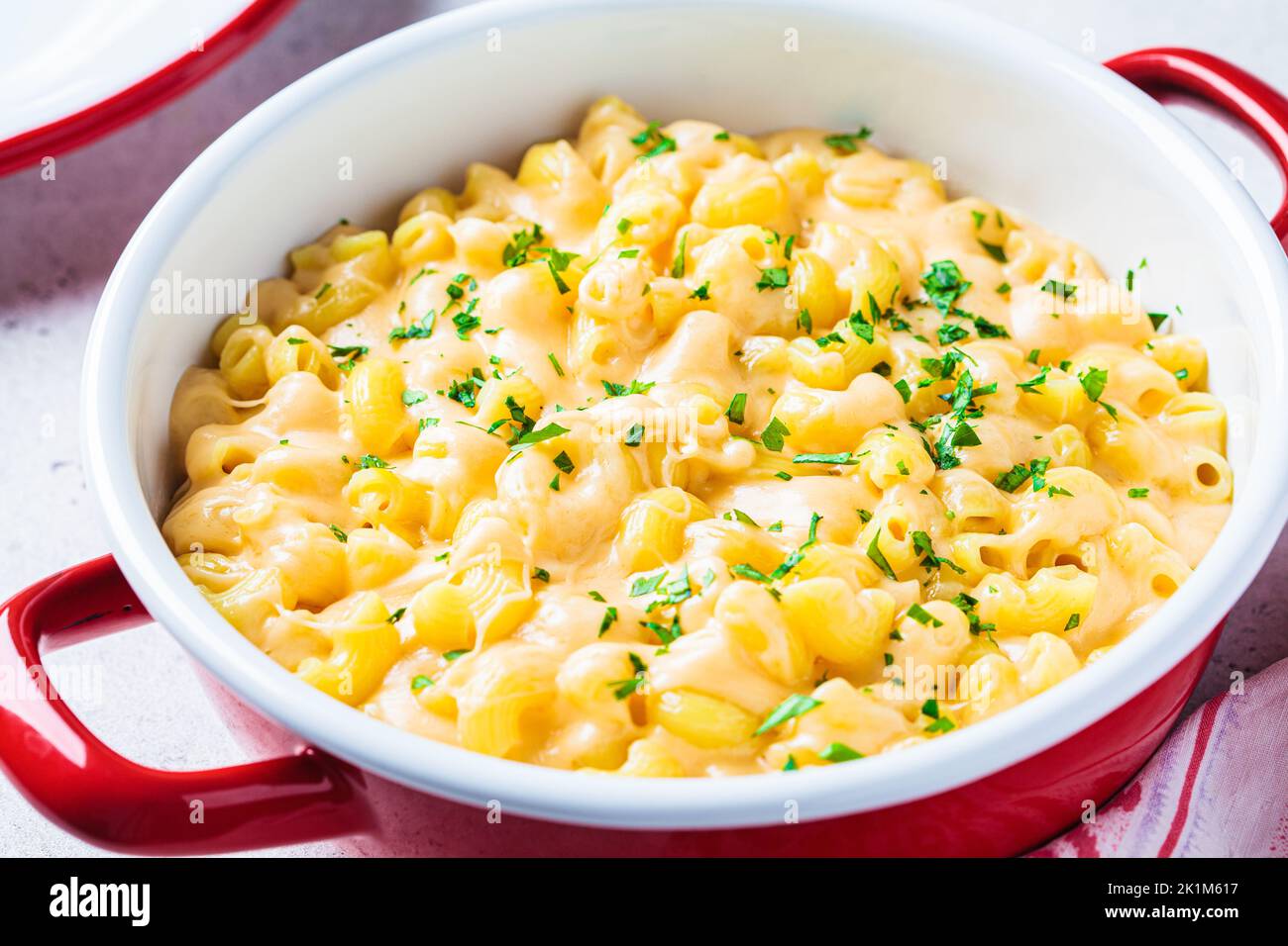 Mac and cheese in red pot, close-up. Traditional American food. Stock Photo