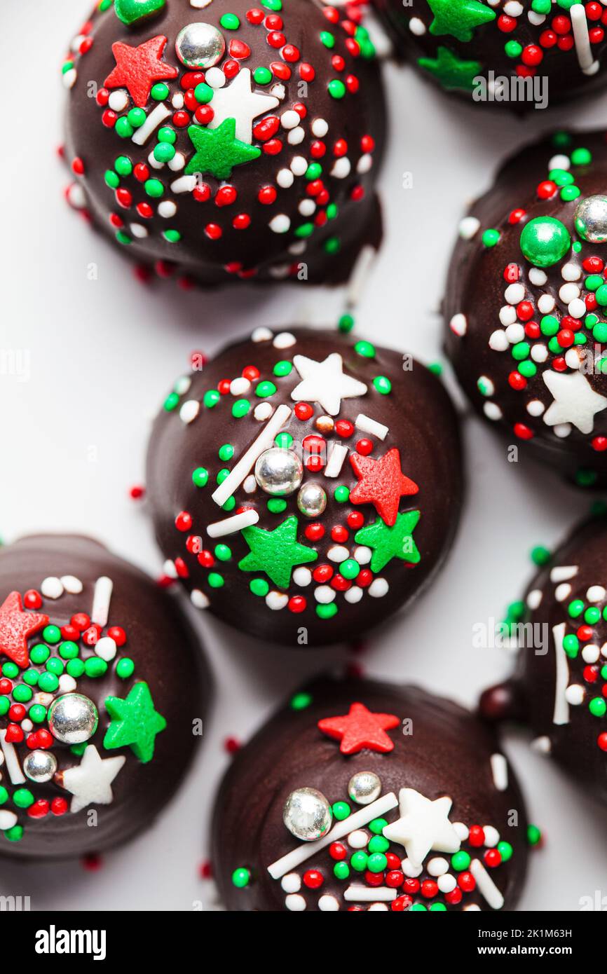 Christmas handmade chocolate balls with holiday sprinkles, top view. DIY holiday cooking, dessert recipe. Stock Photo