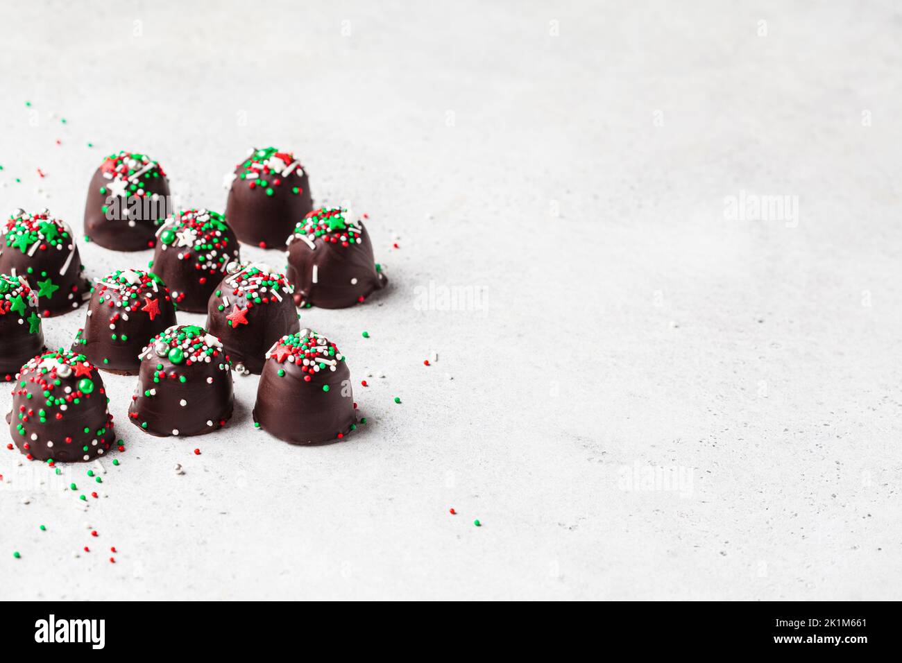 Christmas handmade chocolate balls with holiday sprinkles. DIY holiday gift, dessert recipe. Stock Photo