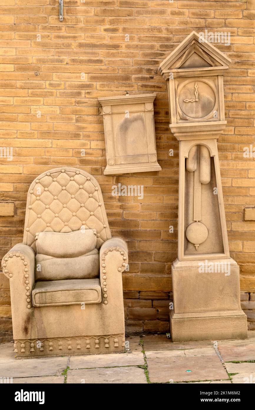 Sandstone sculpture of a millowner’s office with a chair, mirror and grandfather clock in the Little Germany district of Bradford, West Yorkshire. The Stock Photo