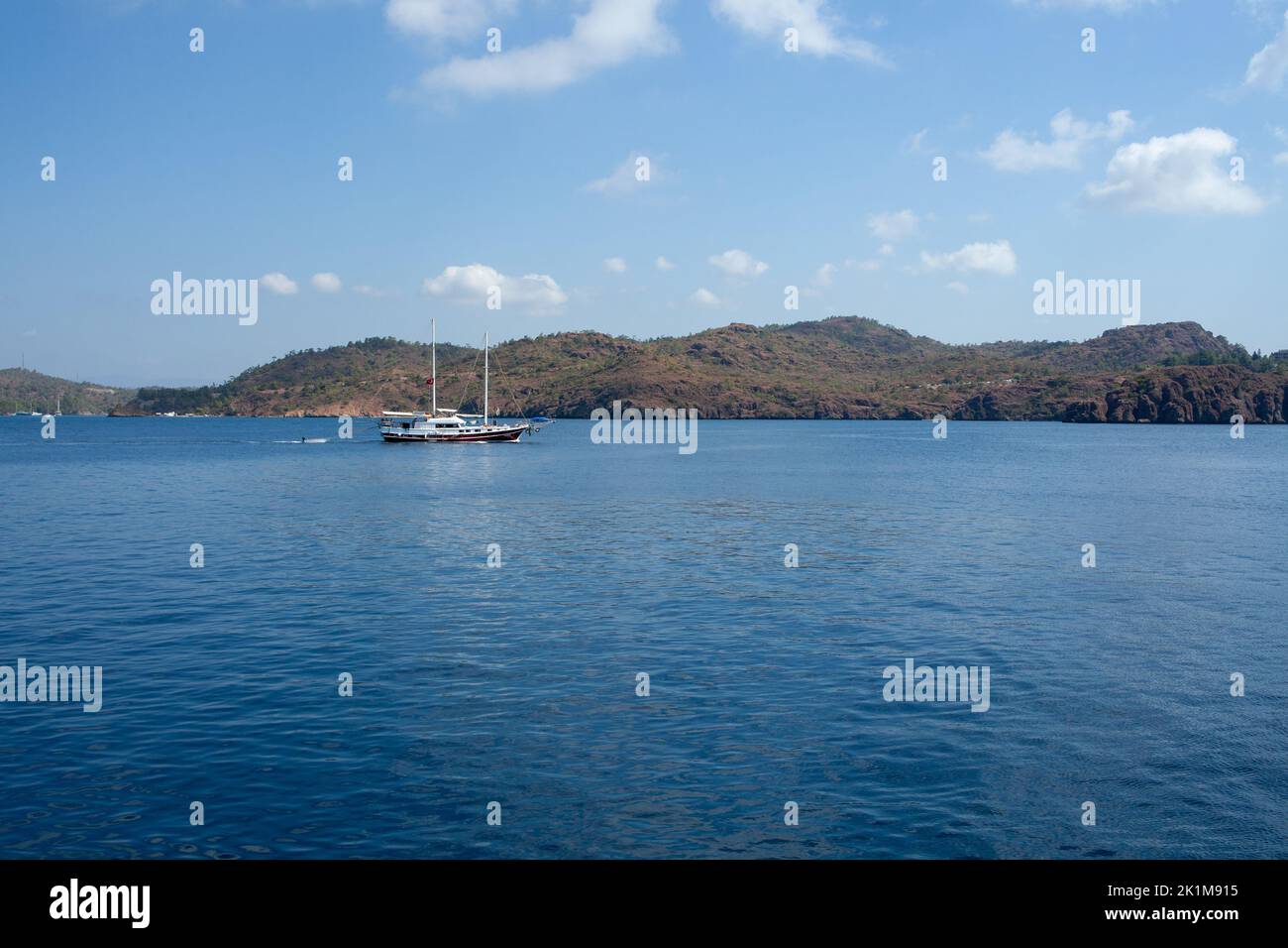 Pleasure yacht in the sea. Tourist ship with people on board with turkish flag sails on the waves. Fast moving excursion ship boat. Marmaris, Turkey - Stock Photo