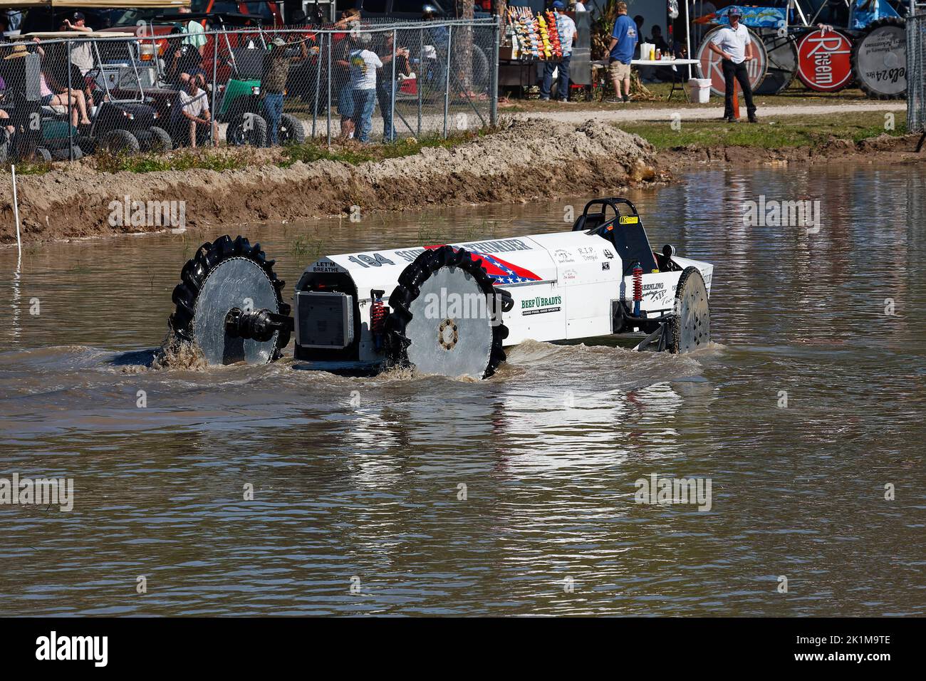 swamp buggy moving through water, action, close-up, motion, jeep style, vehicle sport,  muddy bank, spectators, Florida Sports Park, Naples, FL Stock Photo