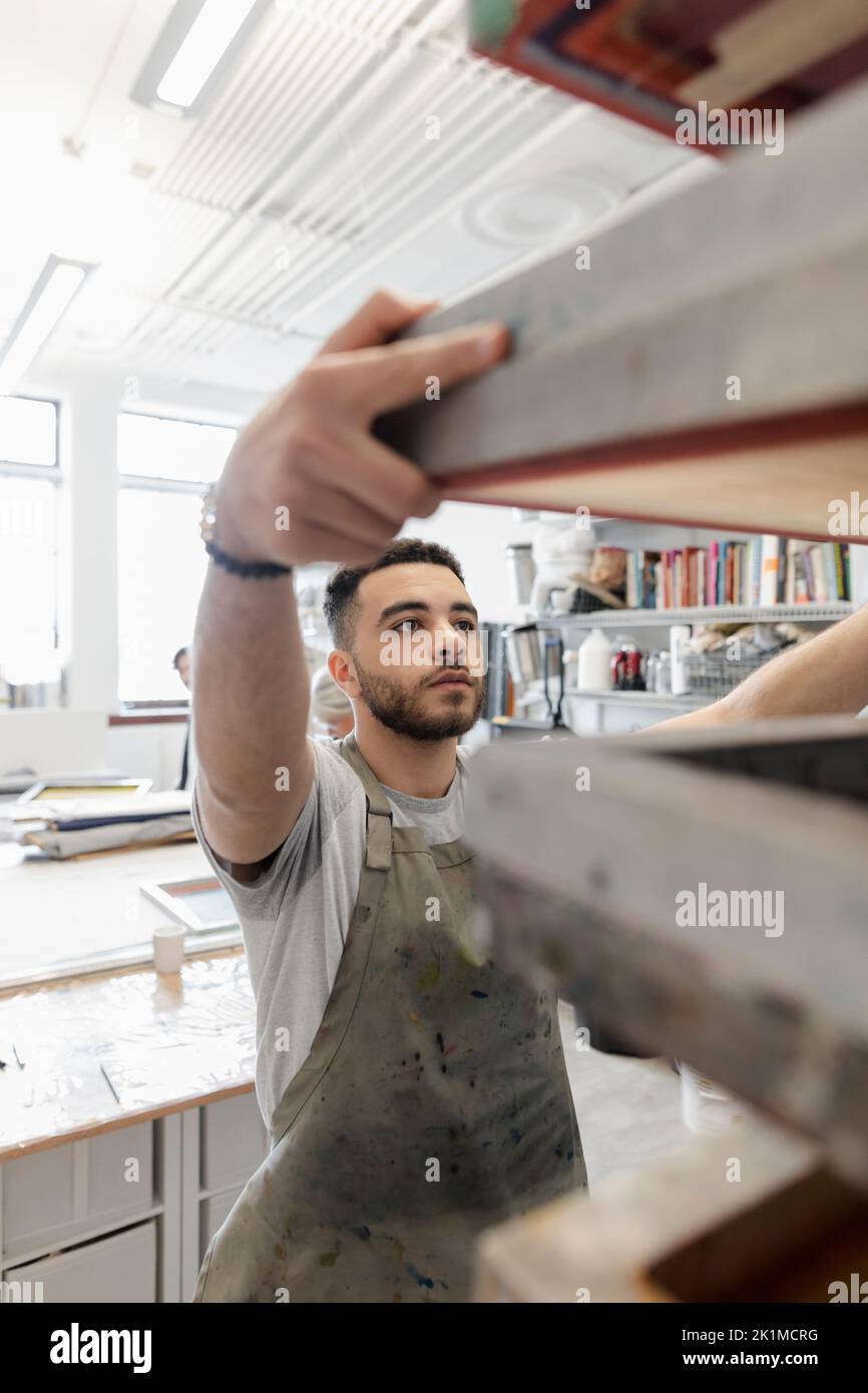 Young man removing screenprinting frame Stock Photo Alamy