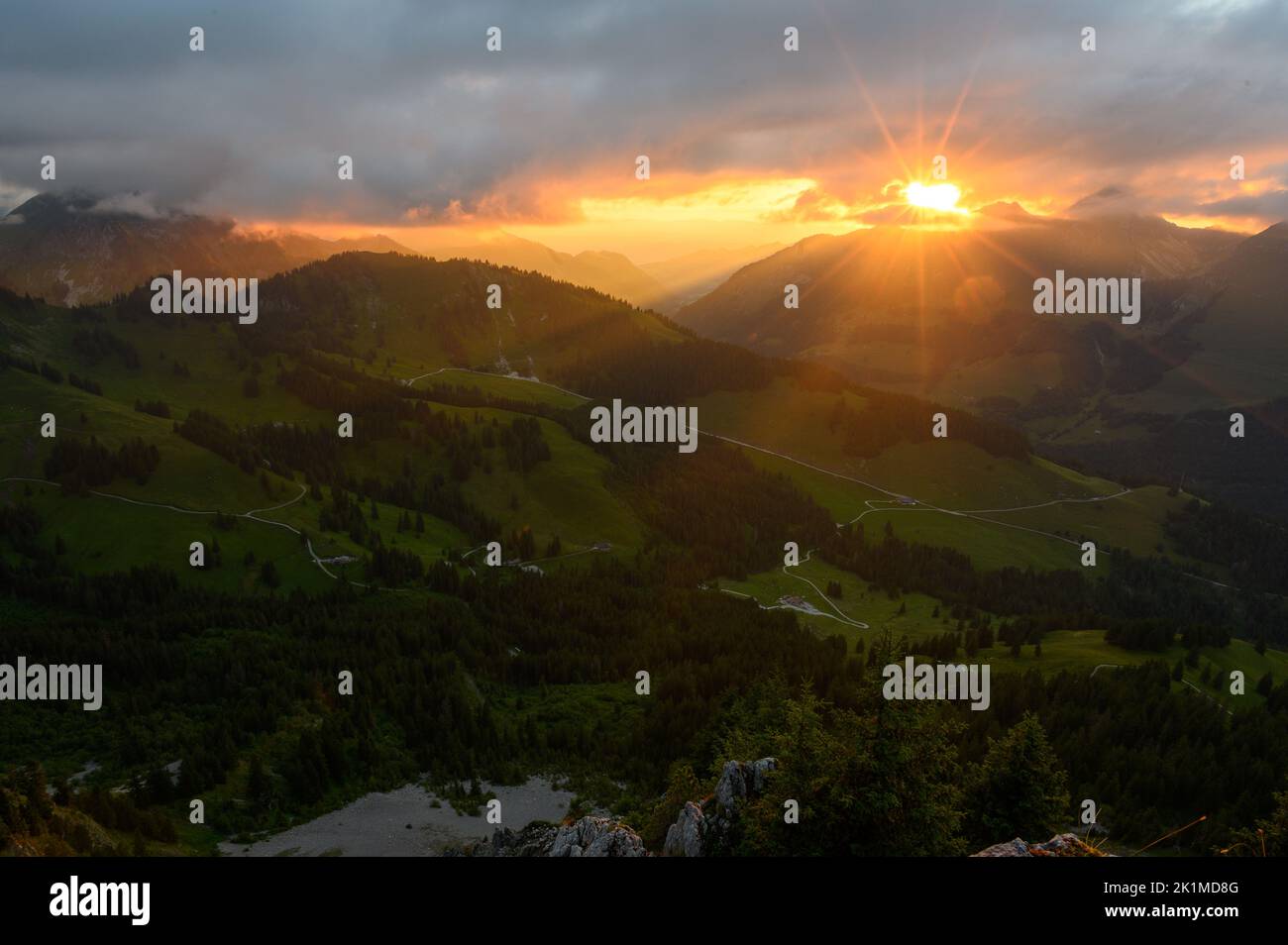 sunstar at sunset over the Gruyeres foothills in Fribourg Stock Photo