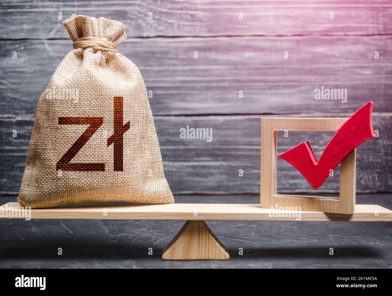 Red vote tick and a polish zloty money bag on scales. Estimating cost of making a decision and consequences in the future. Concept of lobbying for dec Stock Photo