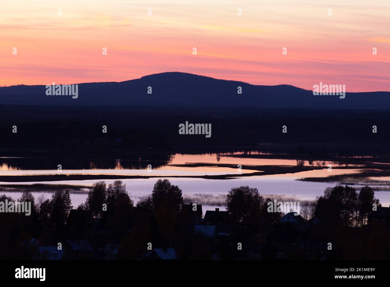 Nightfall up North over forestland, lakes, hills, and ridges. Colorful landscape in Lapland. Stock Photo