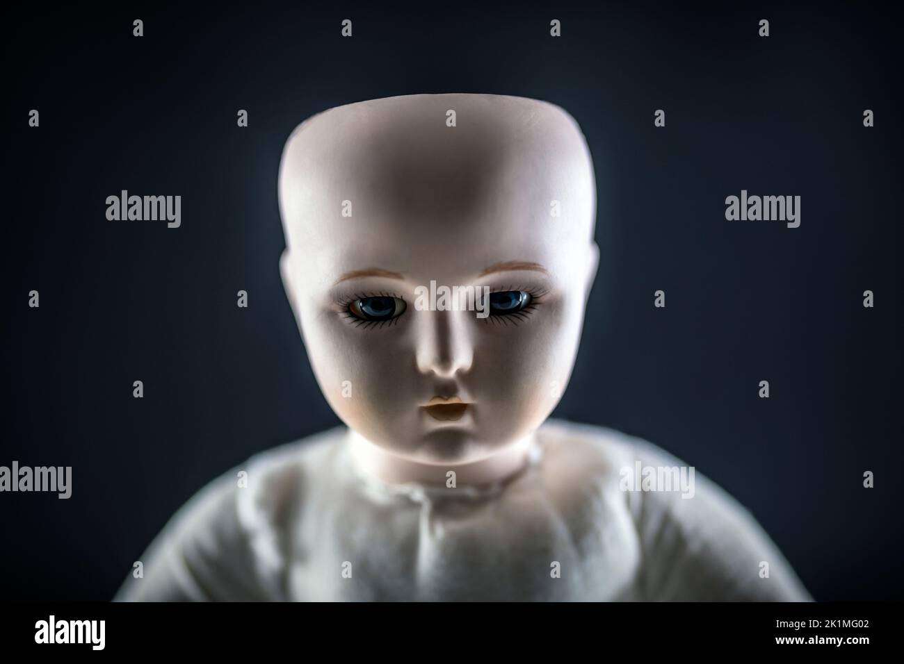 Creepy doll face on dark background Stock Photo