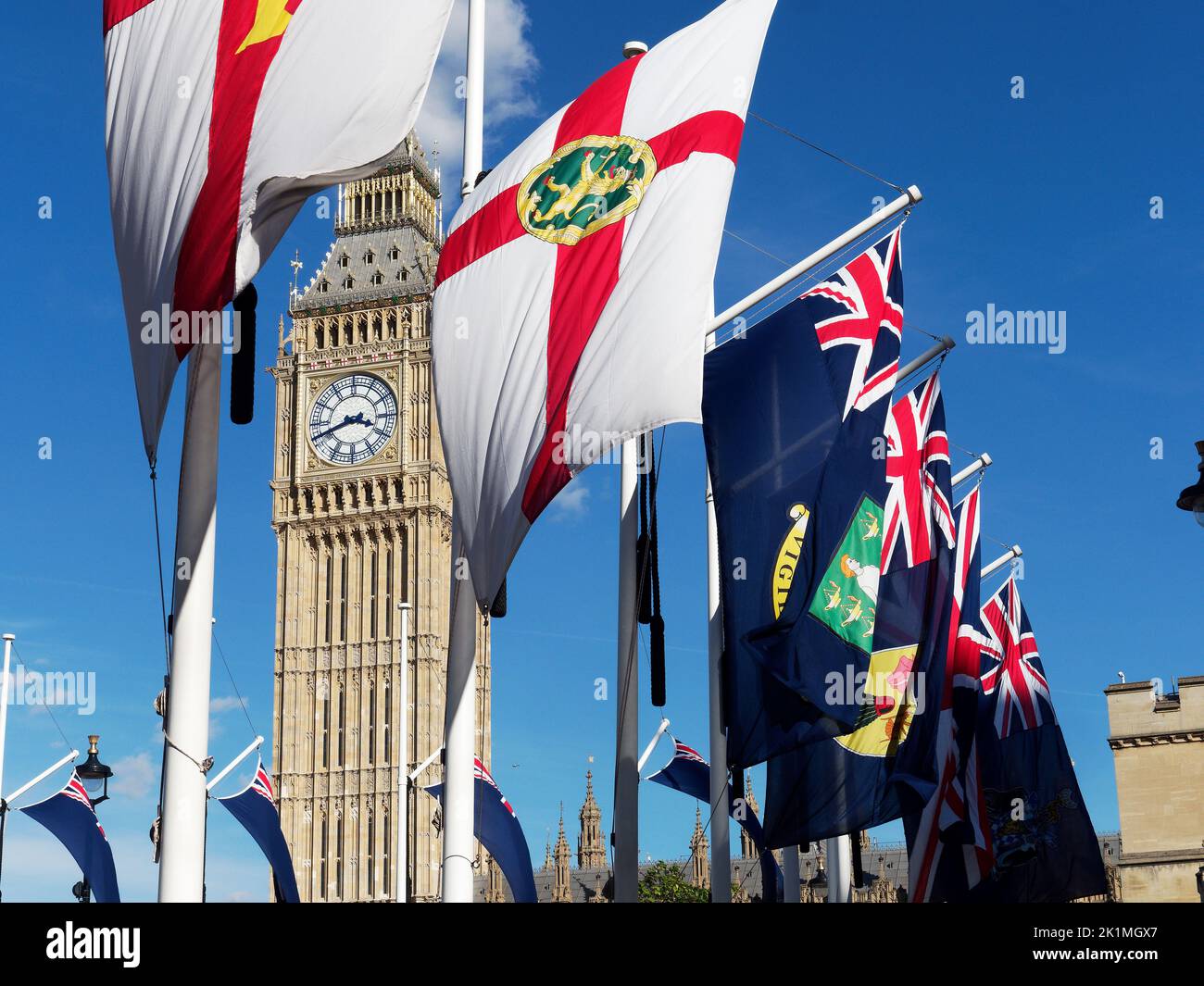 View of the bright shiny new 'Big Ben' behind a row of flags in London 2022 following recent lengthy renovation work Stock Photo