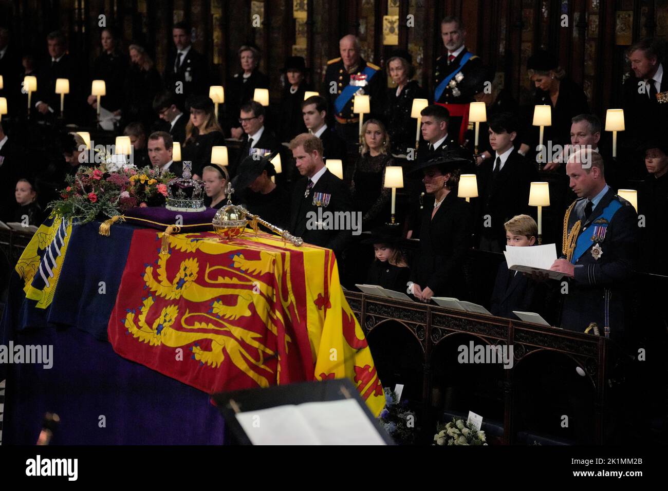 Members of the royal family (front row, left to right) Lena Tindall, Zara Tindall, Mia Tindall, the Duchess of Sussex, the Duke of Sussex, Princess Charlotte, the Princess of Wales, Prince George, and the Prince of Wales, stand for the coffin of Queen Elizabeth II, draped in the Royal Standard with the Imperial State Crown and the Sovereign's orb and sceptre, during the Committal Service at St George's Chapel in Windsor Castle, Berkshire. Picture date: Monday September 19, 2022. Stock Photo