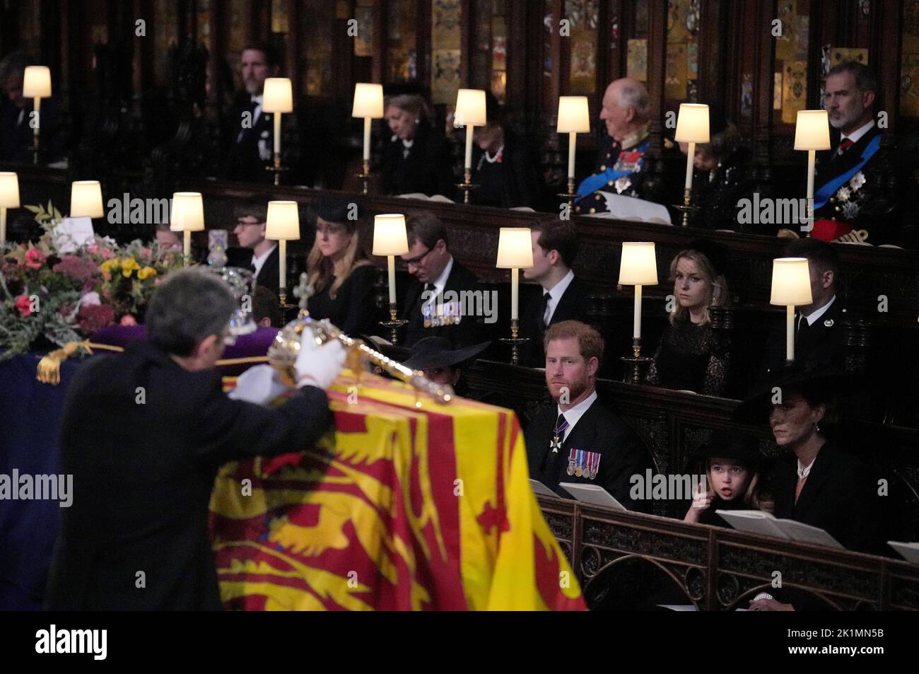(front row, left to right) The Duke of Sussex, Princess Charlotte, the Princess of Wales, Prince George, watch as the Imperial State Crown and the Sovereign's orb and sceptre are removed from the coffin of Queen Elizabeth II, draped in the Royal Standard, during the Committal Service at St George's Chapel in Windsor Castle, Berkshire. Picture date: Monday September 19, 2022. Stock Photo