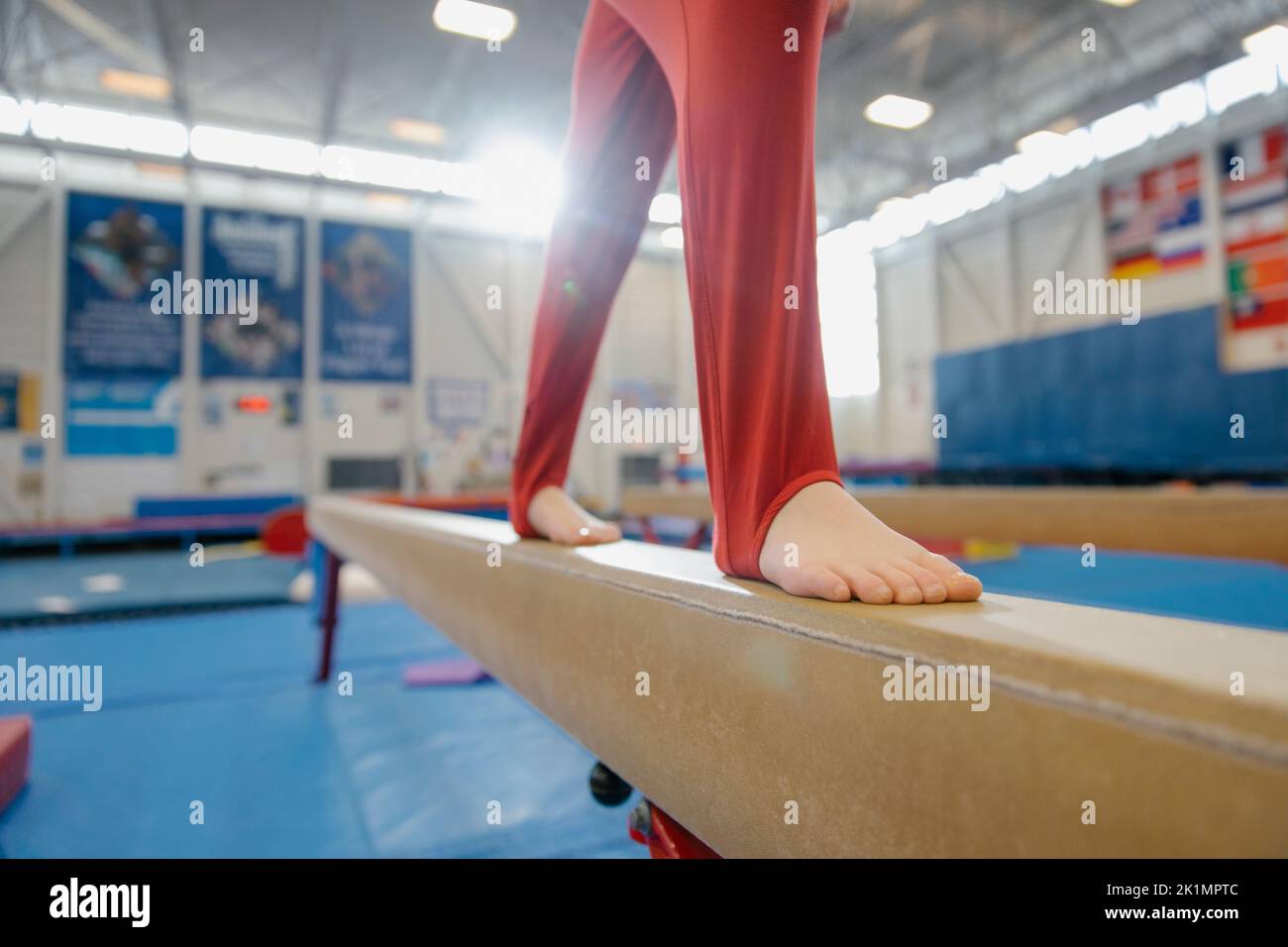 Boy on balance beam in gymnasium Stock Photo