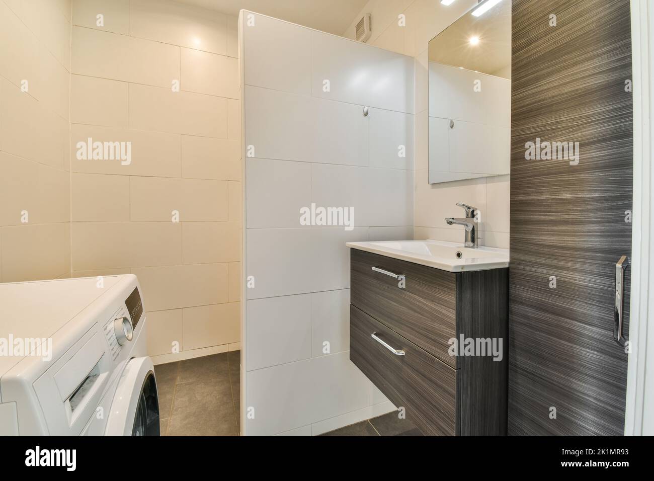 partition between shower tap and wall hung toilet in modern restroom at