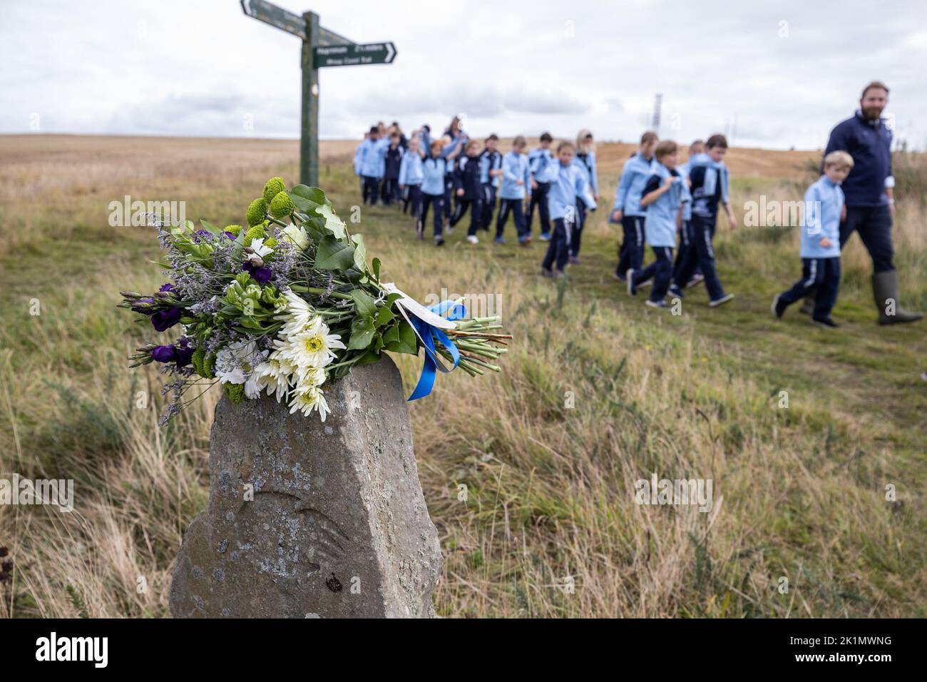 Children and teachers from Gordonstoun School marks the state funeral of Queen Elizabeth II by walking to the Coastguard watchtower at nearby Covesea was opened by Prince Philip in 1955 and was used by King Charles III during his time as a Captain of the Coastguard Service at Gordonstoun. Picture date: Monday September 19, 2022. Stock Photo