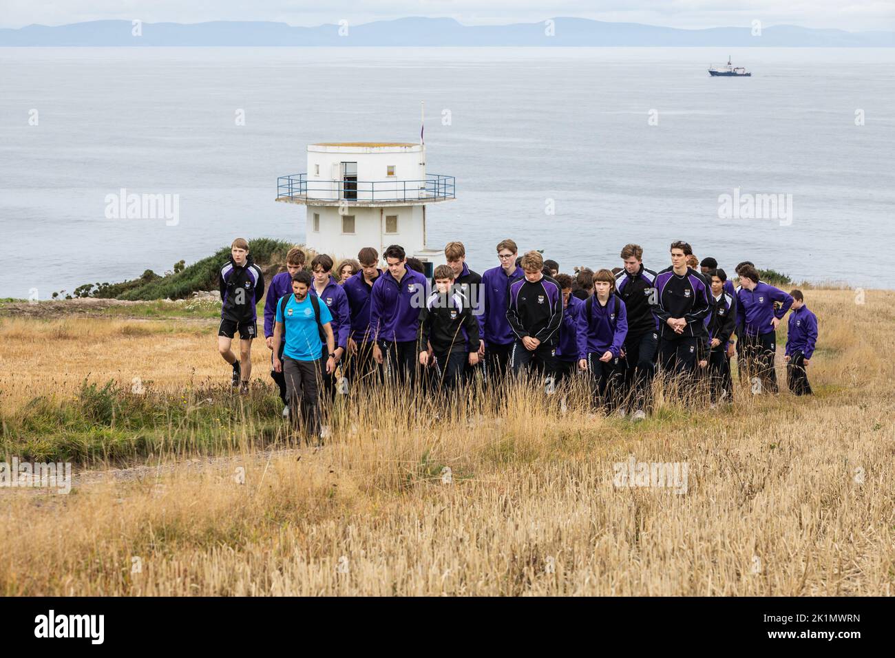 Children and teachers from Gordonstoun School marks the state funeral of Queen Elizabeth II by walking to the Coastguard watchtower at nearby Covesea was opened by Prince Philip in 1955 and was used by King Charles III during his time as a Captain of the Coastguard Service at Gordonstoun. Picture date: Monday September 19, 2022. Stock Photo