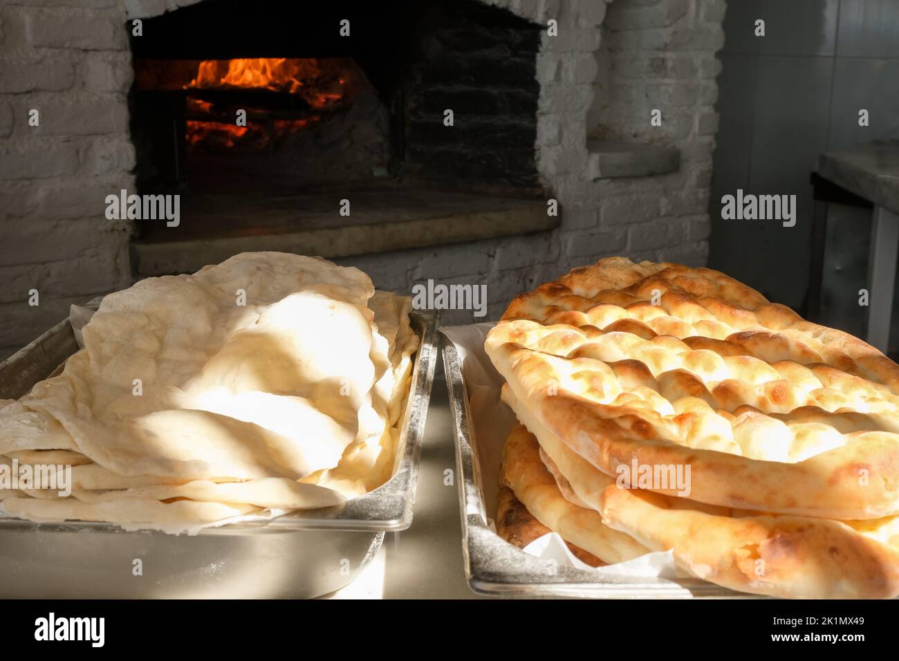 Traditional bread in a Turkish bakery during the Ramadan period - Ramazan pidesi, in a stone oven. Stock Photo