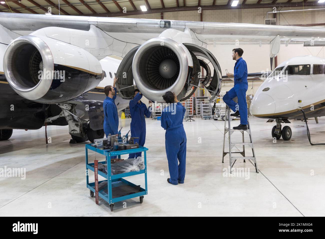 Maintenance team repairing airplane engine in hangar Stock Photo Alamy