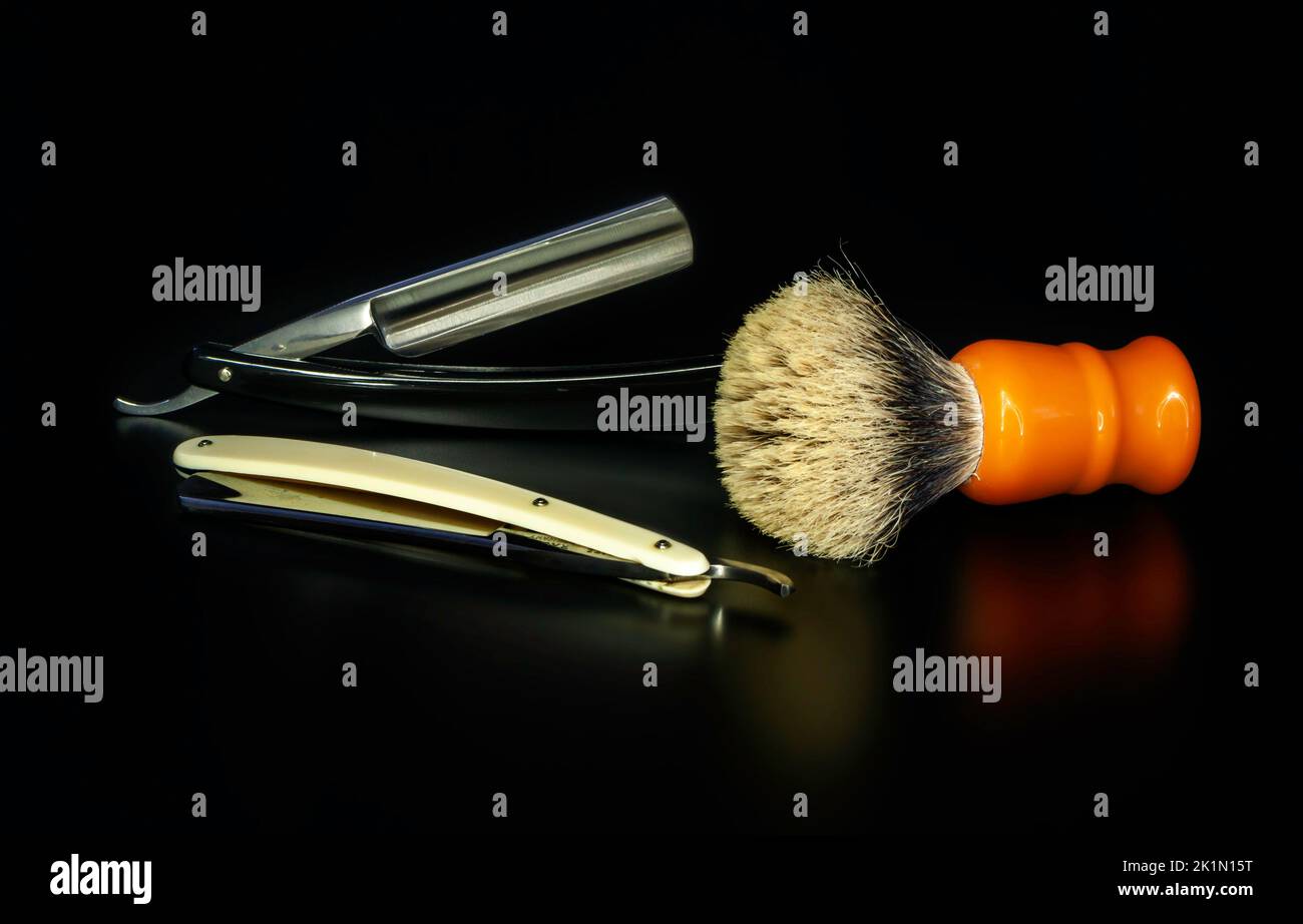 Two straight razors with a silvertip badger on dark background Stock ...
