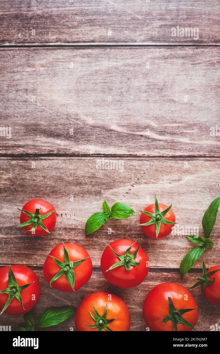 Fresh tomatoes and basil on wooden table, cooking background, top view, copy space Stock Photo