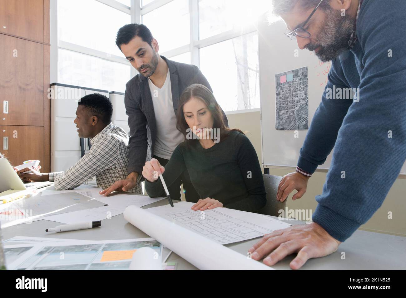 Land use planners reviewing plans in community center meeting Stock
