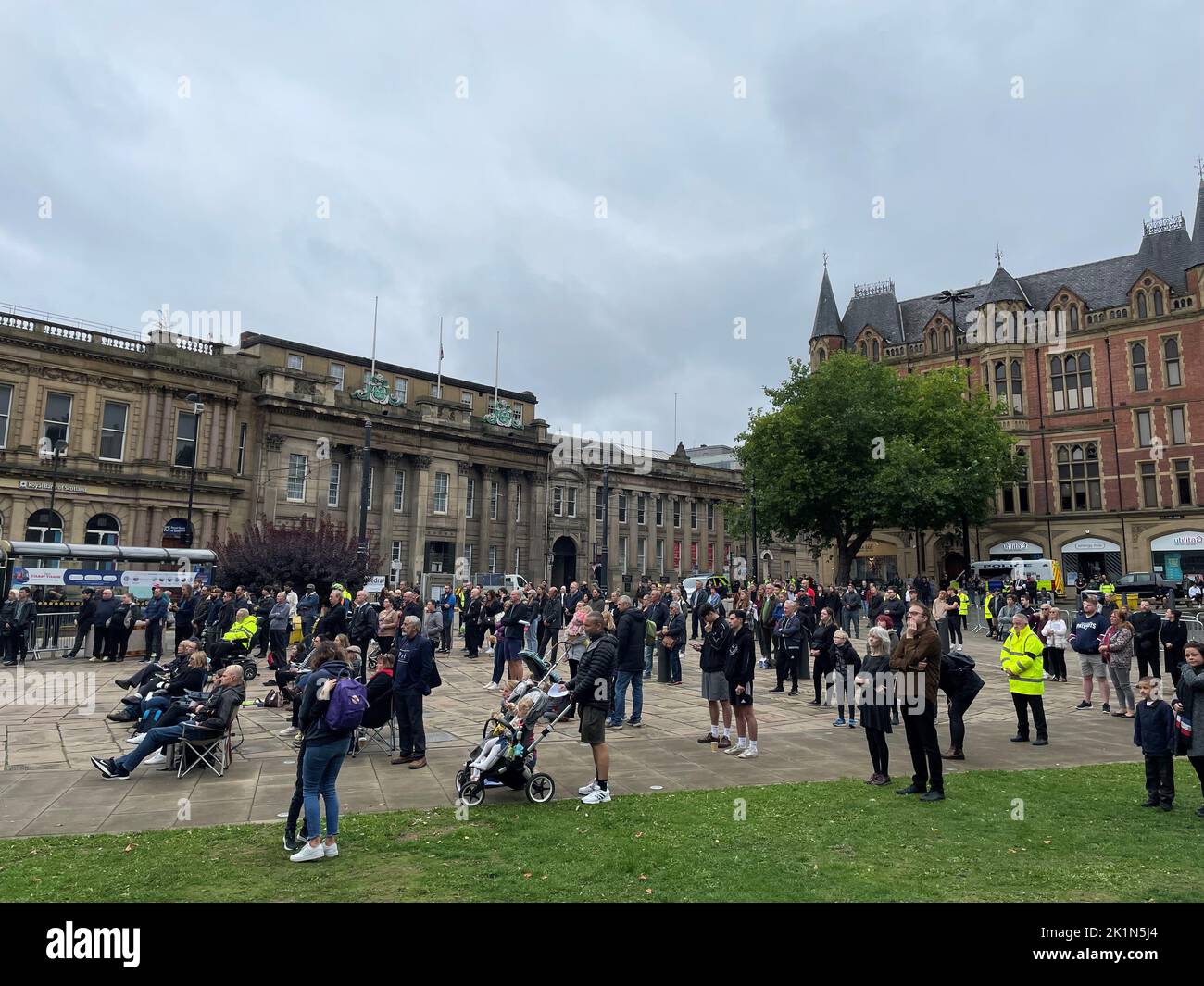 People watch the funeral of Queen Elizabeth II on a big screen outside